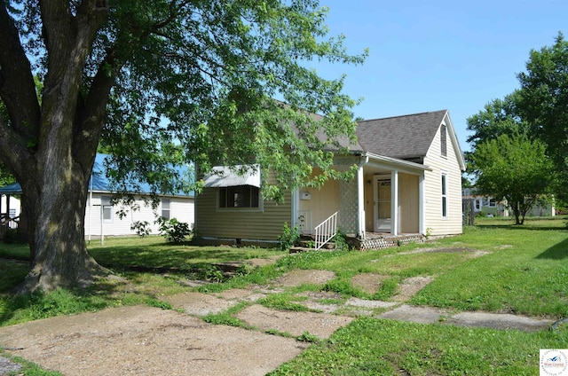 1305 E 14th St, Sedalia, MO 65301 - view of front facade with roof with shingles, a front lawn, and a porch