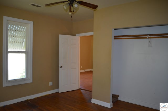 1305 E 14th St, Sedalia, MO 65301 - unfurnished bedroom featuring multiple windows, wood finished floors, baseboards, and a closet