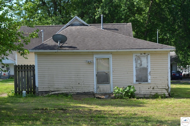 1305 E 14th St, Sedalia, MO 65301 - back of house featuring a lawn and roof with shingles