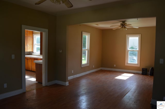 1305 E 14th St, Sedalia, MO 65301 - empty room featuring ceiling fan, wood finished floors, plenty of natural light, and baseboards