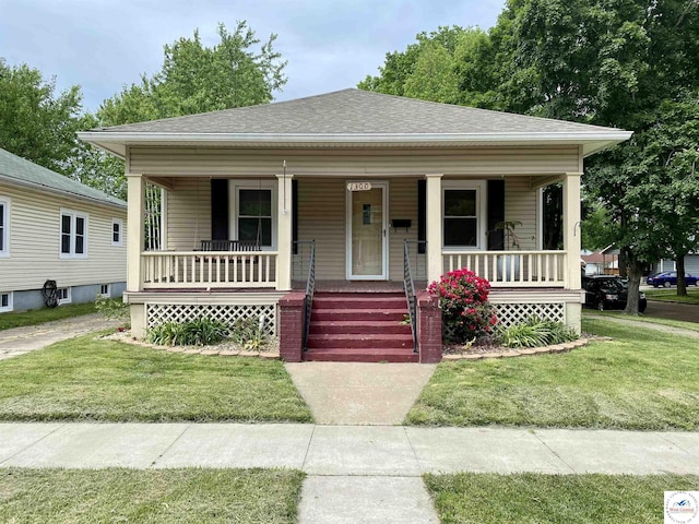 1300 W 16th St, Sedalia, MO 65301 - bungalow-style house featuring covered porch, a shingled roof, and a front yard