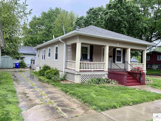 1300 W 16th St, Sedalia, MO 65301 - bungalow-style house featuring driveway, a porch, a storage shed, and a front yard