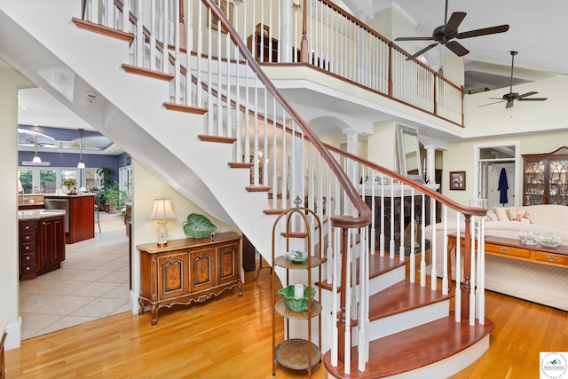 1114 W Broadway Blvd, Sedalia, MO 65301 - stairway with ornate columns, wood finished floors, a ceiling fan, and a high ceiling