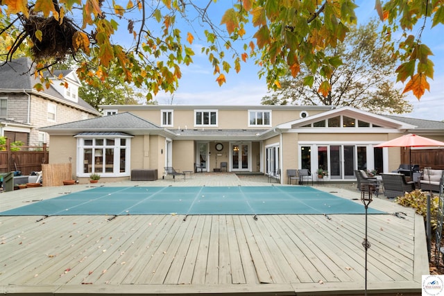 back of house with a deck, french doors, an outdoor living space, and a fenced in pool