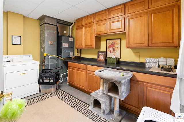 kitchen featuring washer / clothes dryer, dark countertops, a paneled ceiling, and brown cabinets