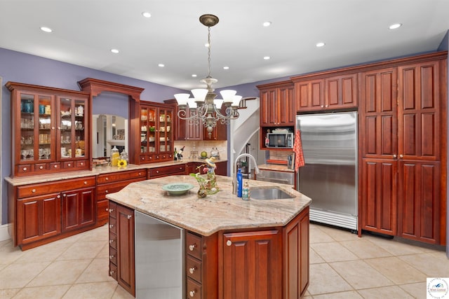 1114 W Broadway Blvd, Sedalia, MO 65301 - kitchen featuring an island with sink, light tile patterned floors, stainless steel refrigerator, a sink, and a notable chandelier