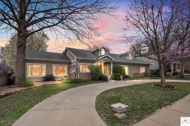 view of front of property featuring fence, a yard, and roof with shingles