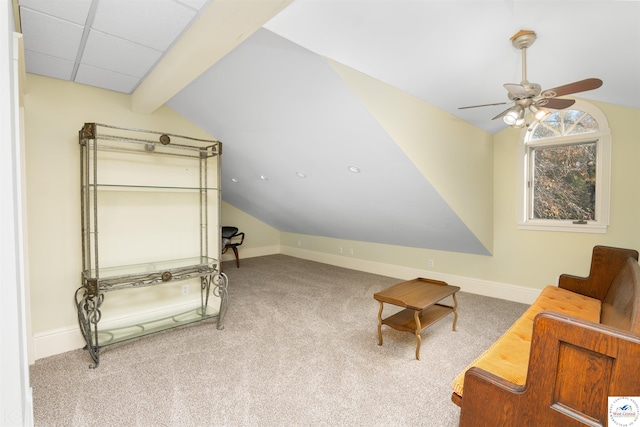 sitting room with baseboards, vaulted ceiling with beams, ceiling fan, and carpet