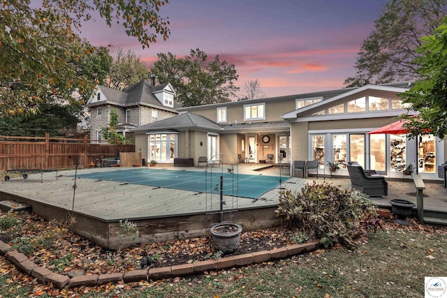 back of house with a patio, an outdoor living space, a fenced in pool, a deck, and fence