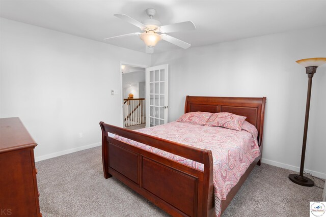 bedroom featuring ceiling fan, light colored carpet, and baseboards