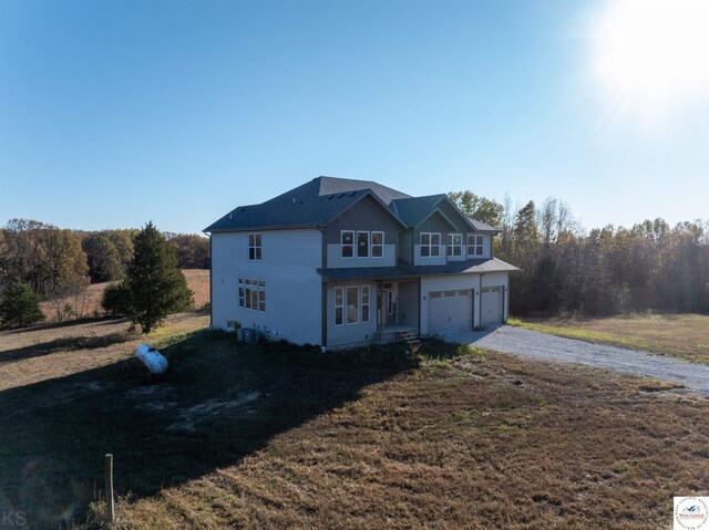 19166 Brockman Ave, Cole Camp, MO 65325 - traditional-style home featuring a front lawn, driveway, and a garage