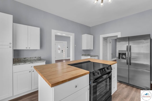 707 E 11th St, Sedalia, MO 65301 - kitchen with wood counters, white cabinetry, black electric range oven, dark wood-style flooring, and stainless steel fridge with ice dispenser