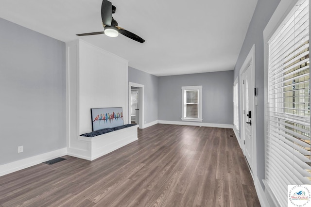 707 E 11th St, Sedalia, MO 65301 - unfurnished living room featuring dark wood finished floors, visible vents, and plenty of natural light