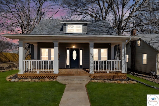 707 E 11th St, Sedalia, MO 65301 - view of front of house featuring a lawn, fence, and a porch