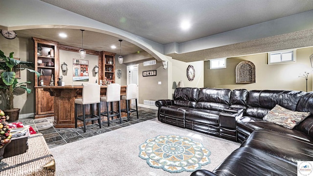 4517 NE Fairway Homes Dr, Lees Summit, MO 64064 - living area with bar, arched walkways, recessed lighting, and a textured ceiling