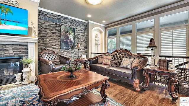 4517 NE Fairway Homes Dr, Lees Summit, MO 64064 - living room featuring crown molding, wood finished floors, a textured ceiling, and a stone fireplace