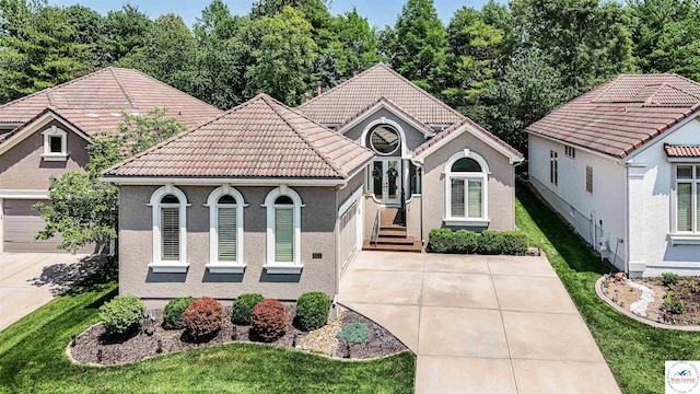 4517 NE Fairway Homes Dr, Lees Summit, MO 64064 - view of front facade featuring driveway, a tiled roof, stucco siding, and a front lawn