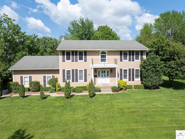 2105 Stonewood Cir, Sedalia, MO 65301 - view of front facade featuring a balcony, a chimney, a front yard, and roof with shingles