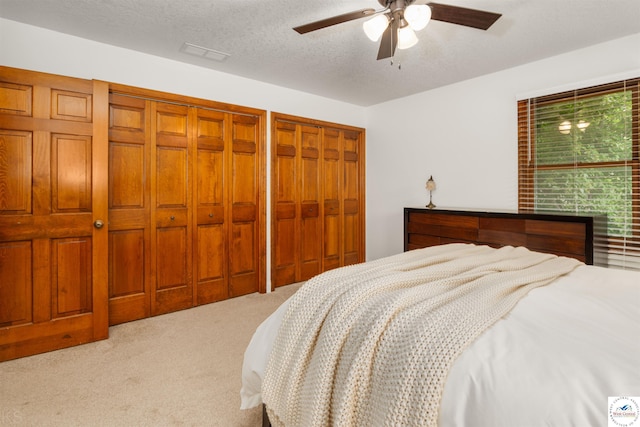 2105 Stonewood Cir, Sedalia, MO 65301 - carpeted bedroom with multiple closets, a ceiling fan, and a textured ceiling