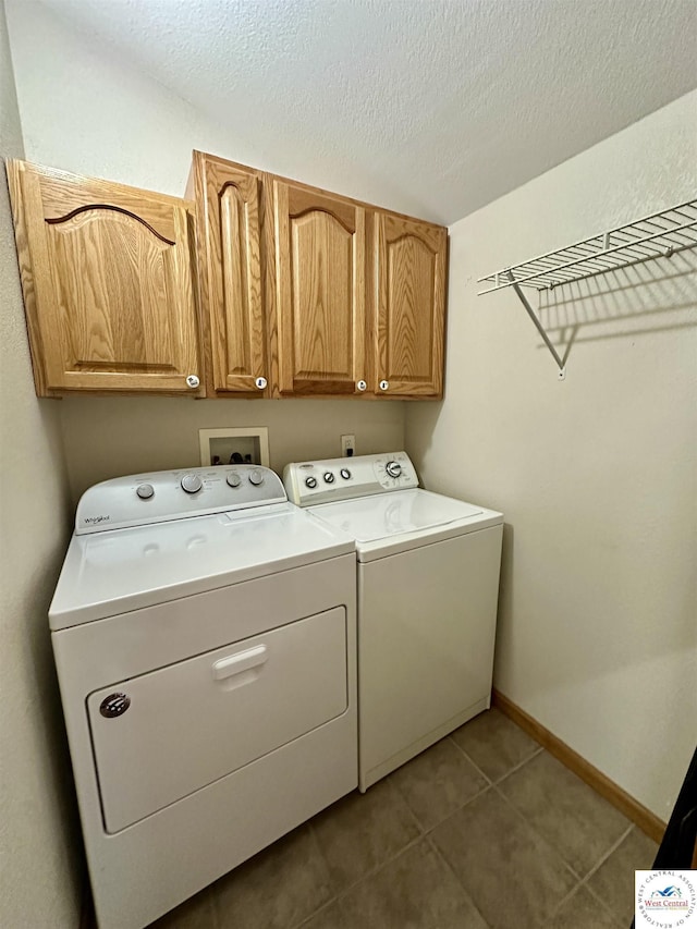 616 E Main St, Warsaw, MO 65355 - laundry area featuring washing machine and clothes dryer, cabinet space, tile patterned flooring, and a textured ceiling