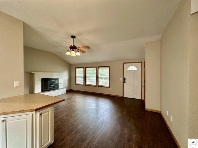 616 E Main St, Warsaw, MO 65355 - unfurnished living room featuring ceiling fan, dark wood-style floors, lofted ceiling, and a glass covered fireplace