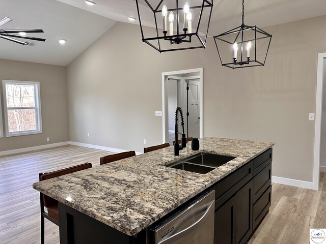 kitchen featuring a chandelier, stainless steel dishwasher, light wood-style flooring, and a sink