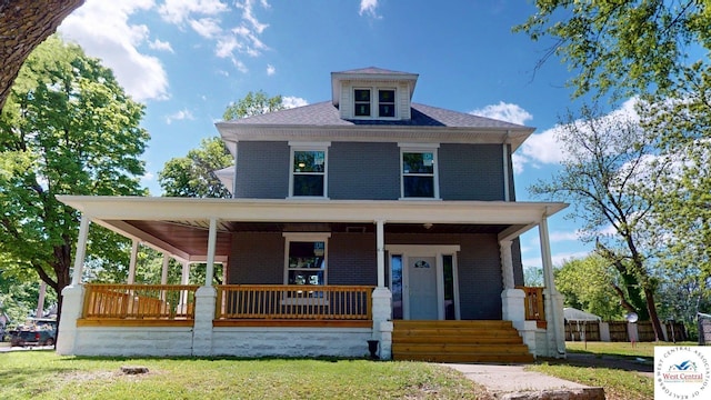 401 N Prospect St, Sedalia, MO 65301 - view of front of house featuring brick siding, covered porch, and a front yard