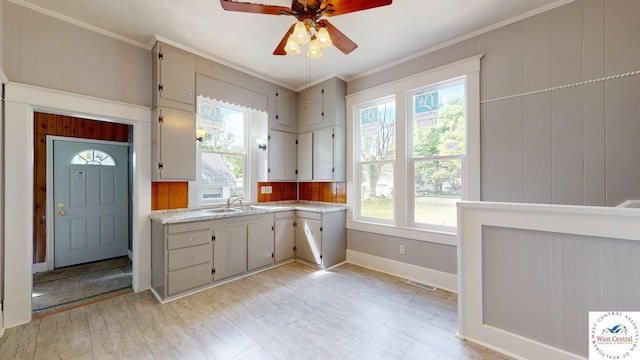 401 N Prospect St, Sedalia, MO 65301 - kitchen with ornamental molding, a ceiling fan, light countertops, baseboards, and a sink