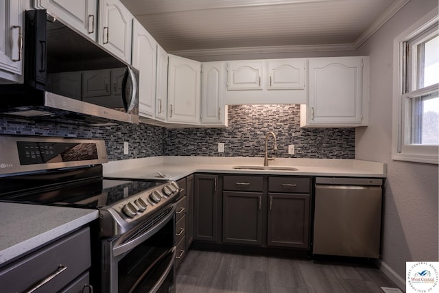 kitchen featuring appliances with stainless steel finishes, tasteful backsplash, white cabinets, and a sink