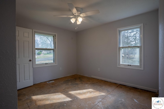 empty room with visible vents, a healthy amount of sunlight, and a ceiling fan