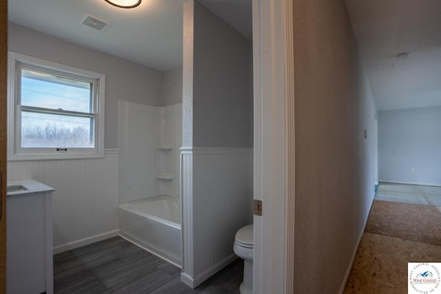 full bathroom featuring toilet, a wainscoted wall, visible vents, wood finished floors, and  shower combination