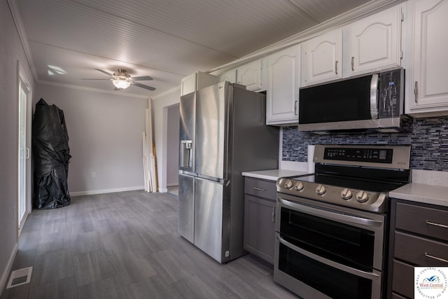 kitchen featuring visible vents, stainless steel appliances, light countertops, and decorative backsplash