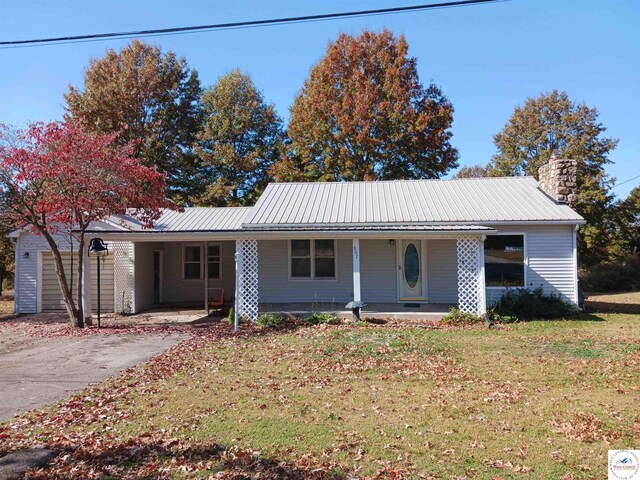 607 N Hughes St, Stover, MO 65078 - single story home with covered porch, a carport, a front yard, and metal roof
