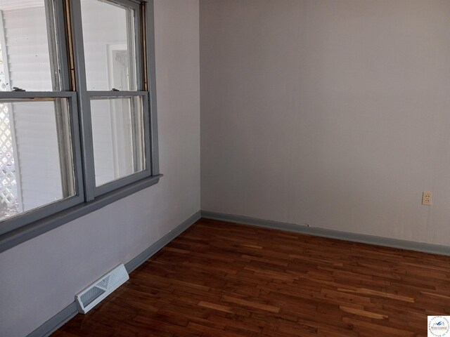 607 N Hughes St, Stover, MO 65078 - spare room featuring visible vents, dark wood finished floors, and baseboards