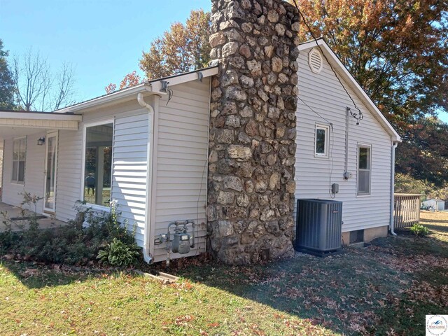 607 N Hughes St, Stover, MO 65078 - view of side of property with a chimney, central AC, and a yard