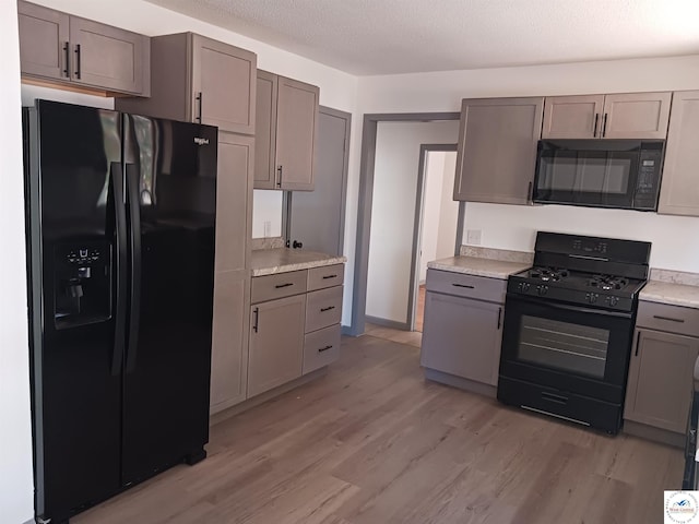 607 N Hughes St, Stover, MO 65078 - kitchen featuring gray cabinets, light wood-type flooring, black appliances, and light countertops