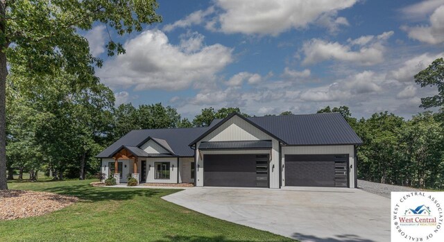26112 Georgetown Ave, Warsaw, MO 65355 - view of front facade featuring metal roof, a front yard, an attached garage, and concrete driveway