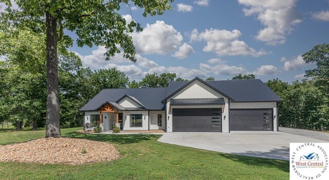 26112 Georgetown Ave, Warsaw, MO 65355 - view of front of property with metal roof, a front yard, concrete driveway, and a garage