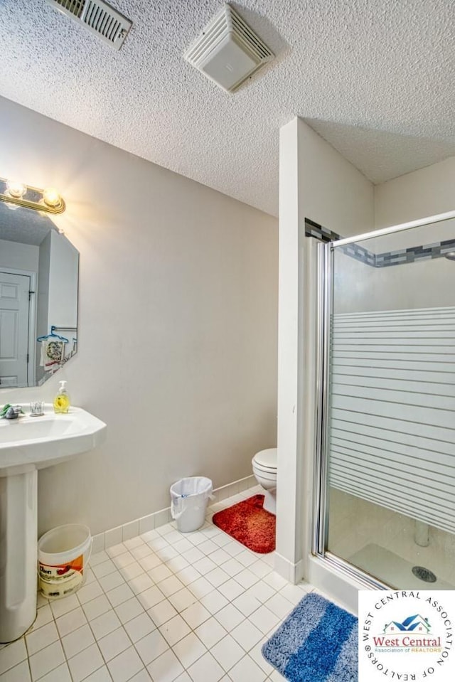 full bath featuring tile patterned floors, a textured ceiling, visible vents, and a stall shower