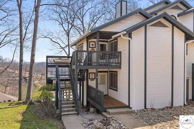 1436 Cherokee Rd, Lake Ozark, MO 65049 - back of property with a wooden deck, stairway, and a chimney