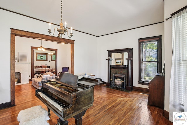 309 E Gay St, Warrensburg, MO 64093 - home office featuring a brick fireplace, a chandelier, and wood finished floors