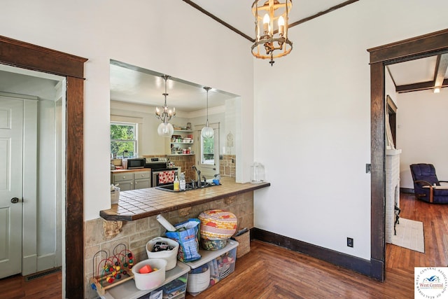 309 E Gay St, Warrensburg, MO 64093 - kitchen with a chandelier, crown molding, appliances with stainless steel finishes, tile counters, and hanging light fixtures