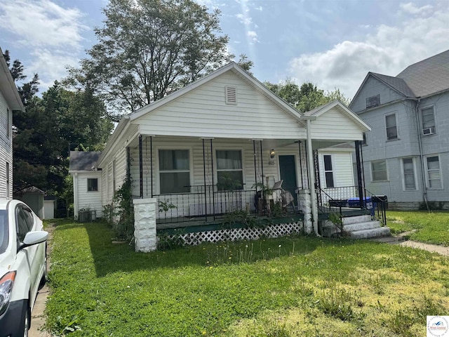 405 W 4th St, Sedalia, MO 65301 - view of front of property featuring covered porch, cooling unit, and a front lawn