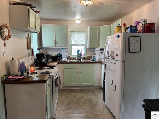 405 W 4th St, Sedalia, MO 65301 - kitchen featuring a sink, dark countertops, green cabinetry, and white appliances
