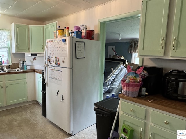 405 W 4th St, Sedalia, MO 65301 - kitchen with a sink, dark countertops, green cabinets, and freestanding refrigerator