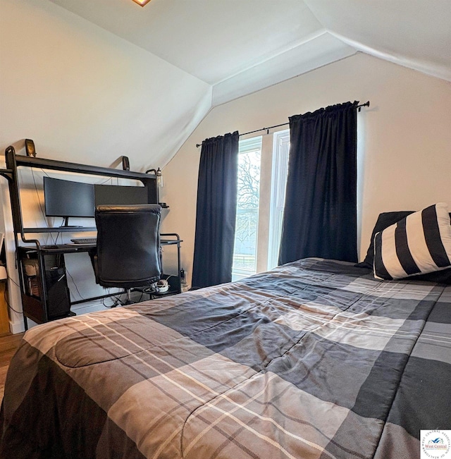 bedroom with vaulted ceiling and wood finished floors