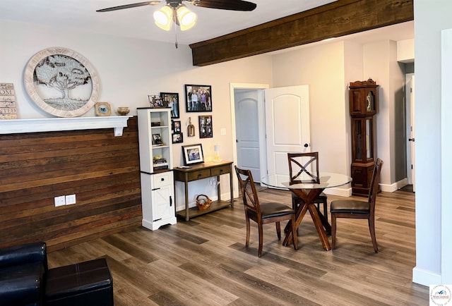 dining area with baseboards, a ceiling fan, beam ceiling, and dark wood-type flooring