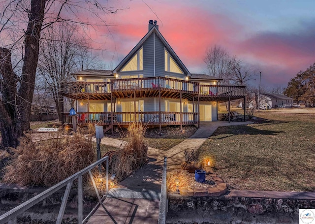 back of property at dusk featuring a deck, a yard, and a chimney