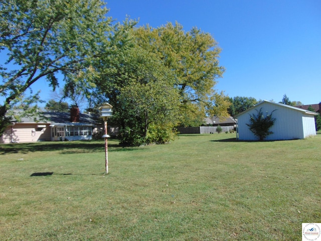 view of yard featuring an outdoor structure and fence