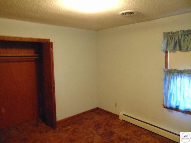 unfurnished bedroom with baseboard heating, visible vents, and carpet